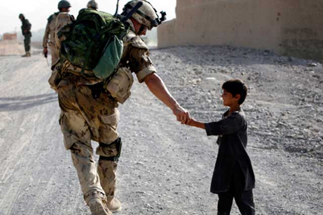 Soldier greets child in warzone